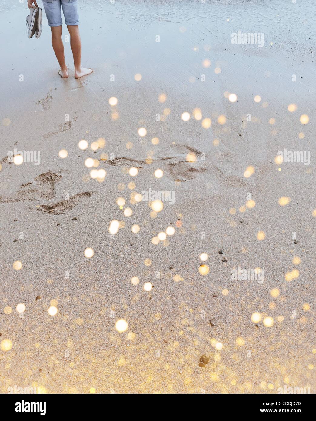 Uomo in piedi nudi sulla spiaggia sabbiosa con festa luccica. Relax nella natura. Sfondo, copia di testo Foto Stock