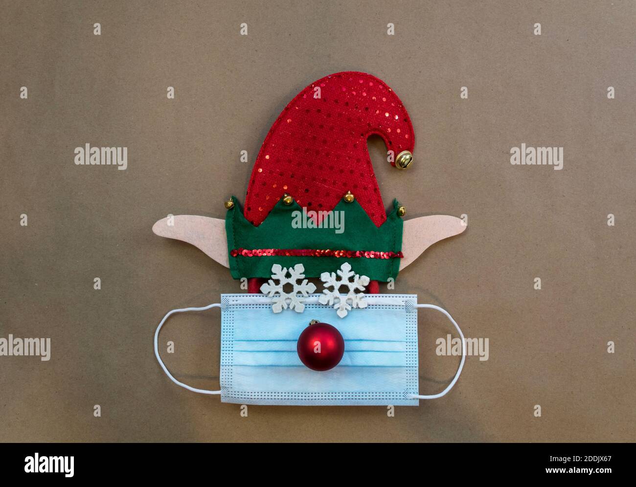Elfo cappello festivo con maschera facciale e ornamenti per inverno,  Natale, Capodanno, dicembre, carta marrone fondo piatto Foto stock - Alamy