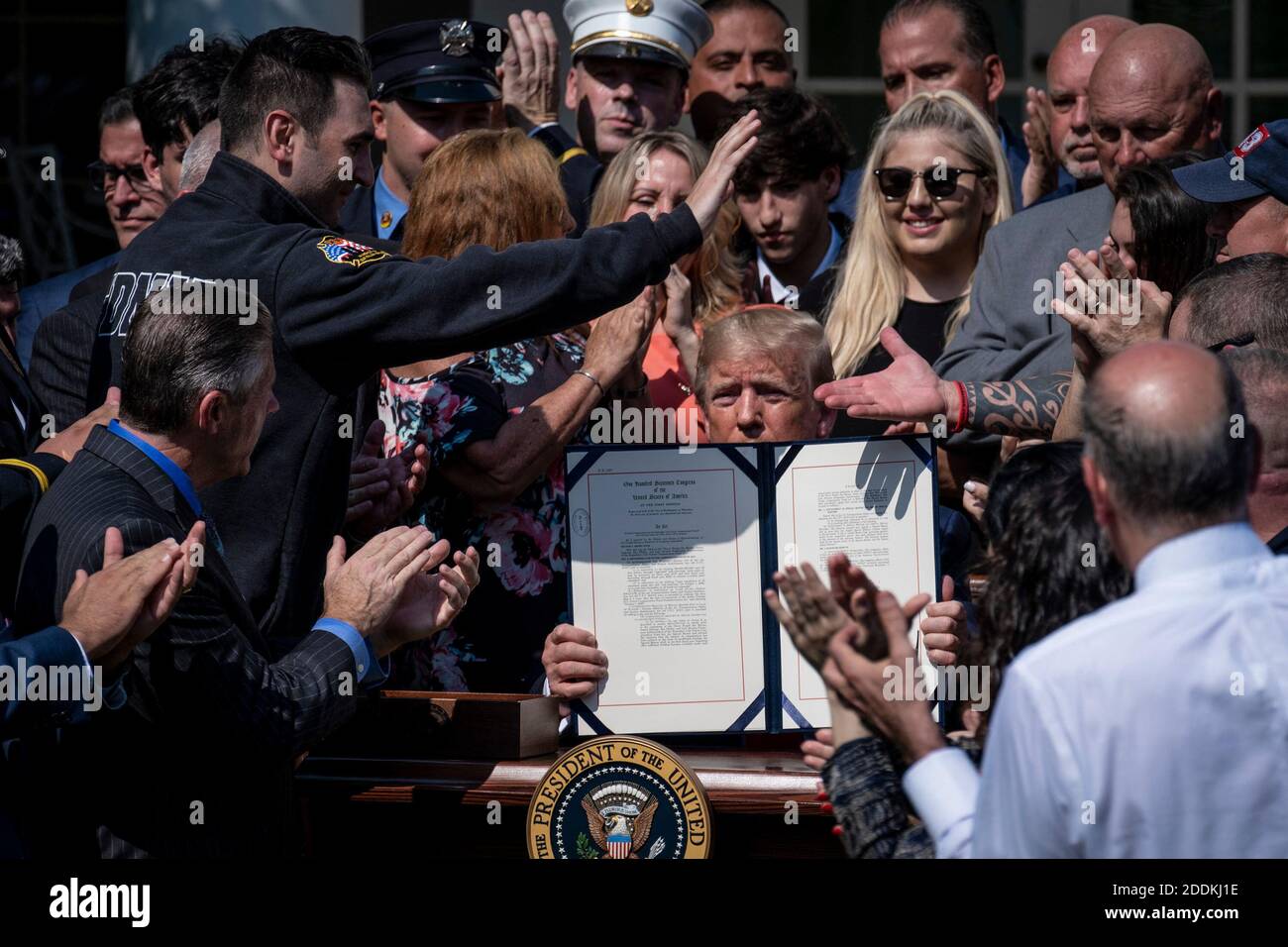 Circondato da 9/11 soccorritori, il presidente Donald Trump mostra il disegno di legge che ha appena firmato nel Rose Garden della Casa Bianca, che rende permanente un fondo speciale federale di risarcimento destinato ad aiutare ad alleviare le sofferenze ancora inflitte alle vittime degli attacchi del 9/11. Luglio 29, 2019 a Washington, D.C. Foto di Pete Marovich/ABACAUSA.com Foto Stock