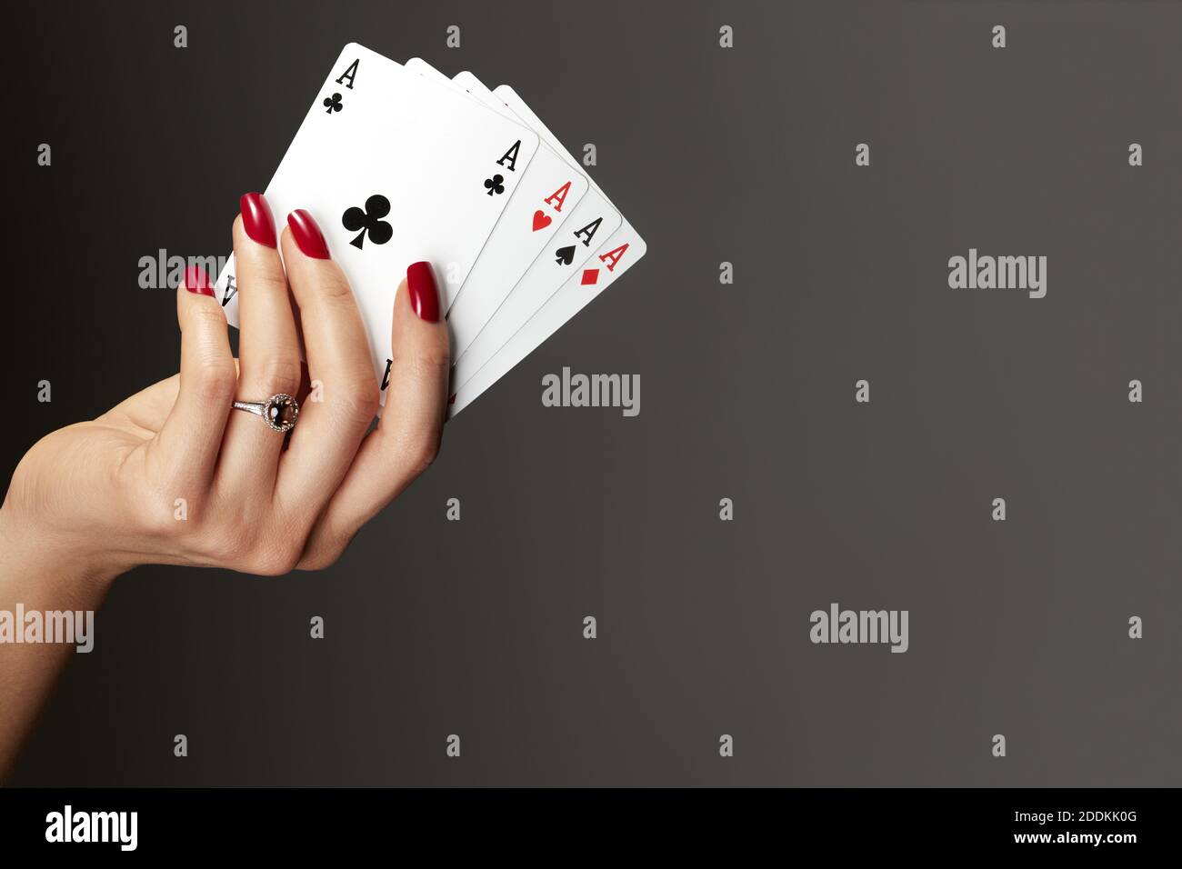 Quattro assi che giocano le carte in mano della donna. Giocatore con combinazione di quads di poker. Eleganti mani femminili con manicure rossa sui chiodi. Foto Stock