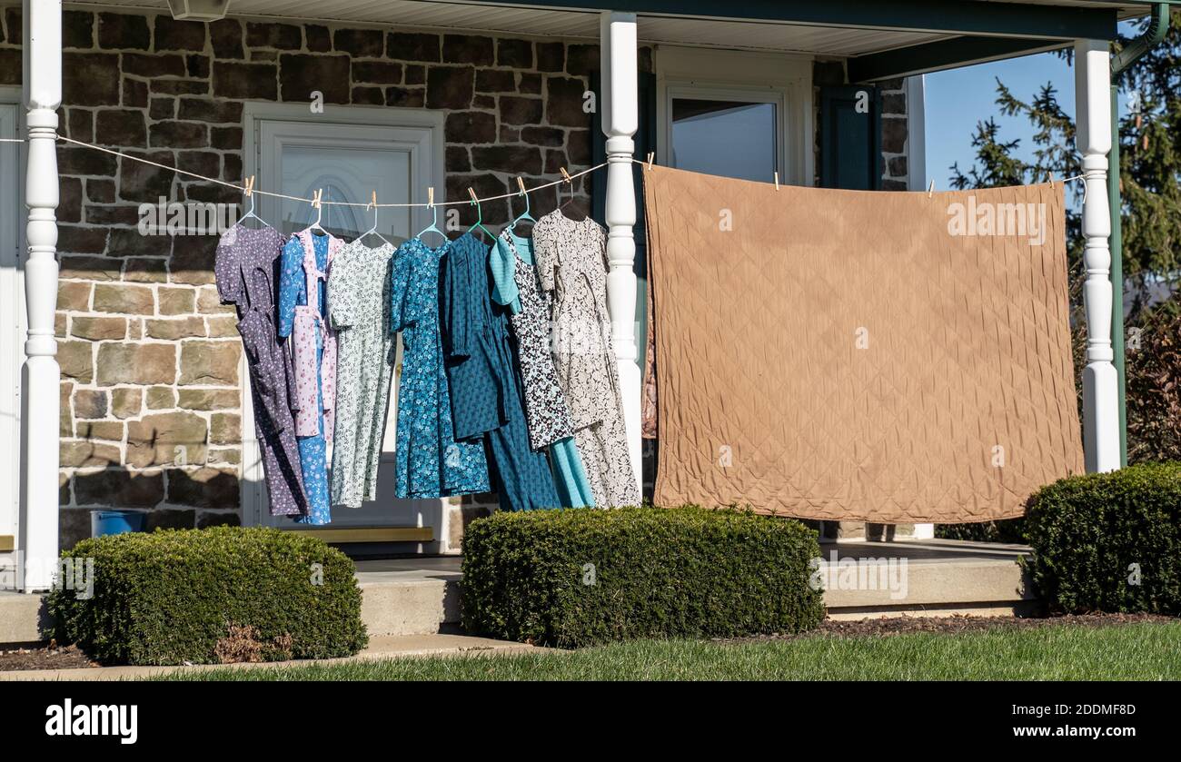 Gli abiti pendono sugli abiti mentre si asciugano sul portico anteriore Stendibiancheria nella fattoria di Mennonte Foto Stock