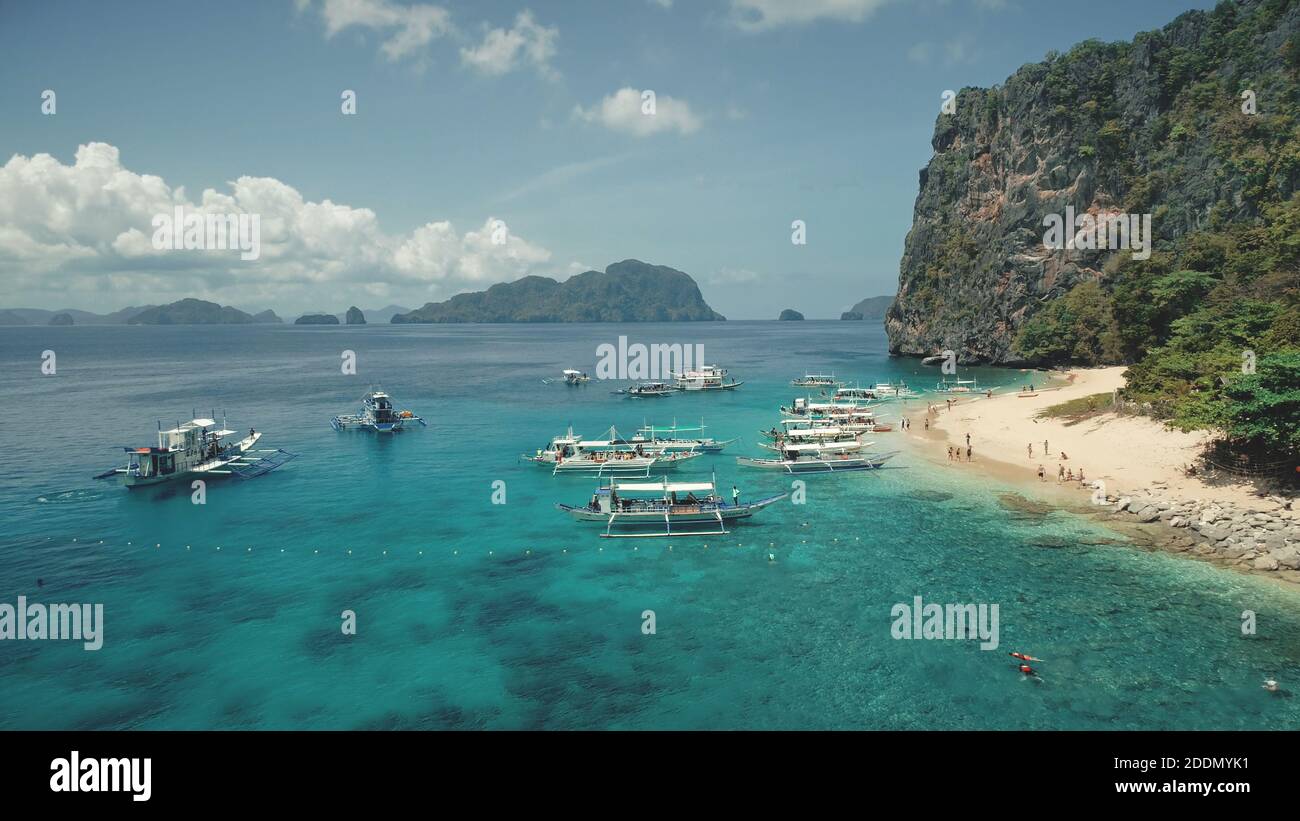 Vista aerea del paradiso delle vacanze sulle barche passeggeri. I turisti riposano alla spiaggia di sabbia dell'isola di Palawan, Filippine, arcipelago di Visayas. Tropic natura altopiano paesaggio con foresta verde durante il giorno d'estate Foto Stock