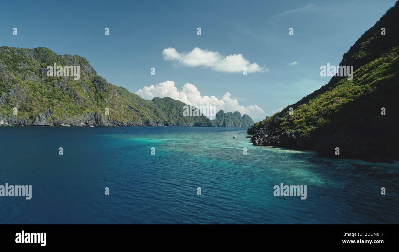 Vista aerea dalla scogliera verde scura della baia del mare. Estate Nessuno stagcape sulla costa rocciosa dell'oceano con acque turchesi e azzurre scintillanti. Una vacanza epica a Palawan, El Nido Islands, arcipelago delle Filippine Foto Stock