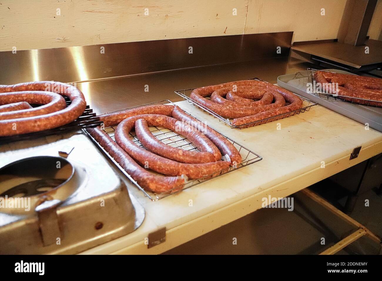Scaffali di salsiccia di prosciutto avvolta all'aglio su un banco macellai Foto Stock
