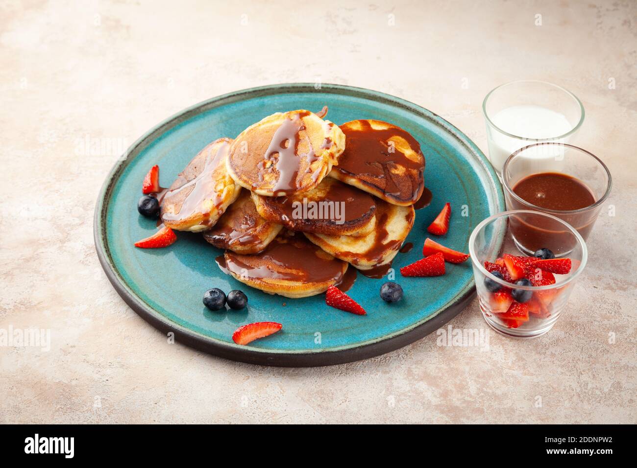 Porzione di pancake fragola, mirtillo, noci, cioccolato liquido Foto Stock