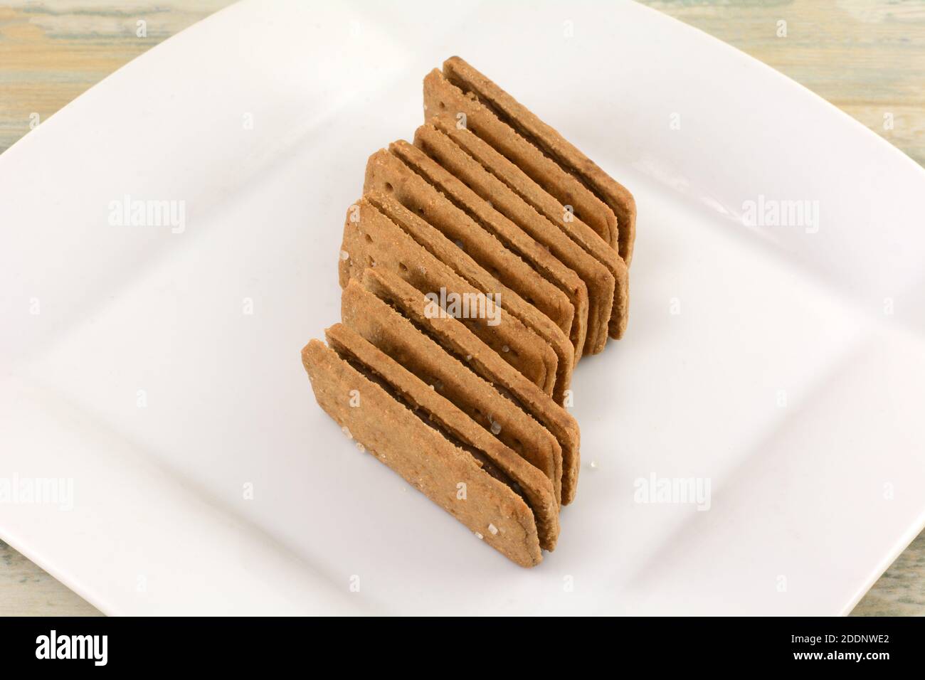 Pila di biscotti al panino riempiti di crema di cioccolato su uno spuntino bianco piastra Foto Stock