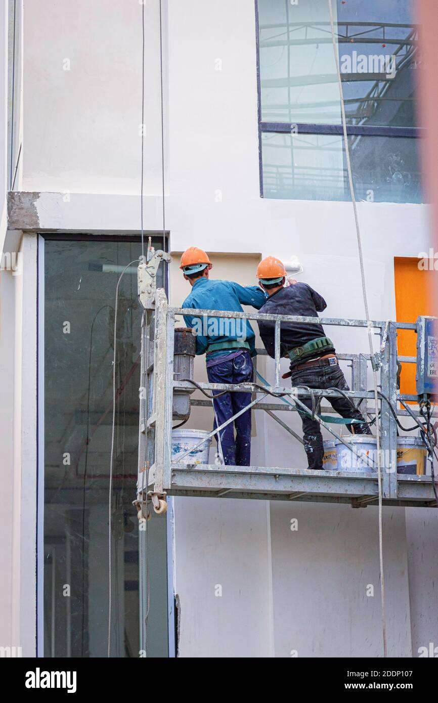 Pittore è al lavoro su un edificio condominio di nuova costruzione in vienam nha trang. Foto Stock