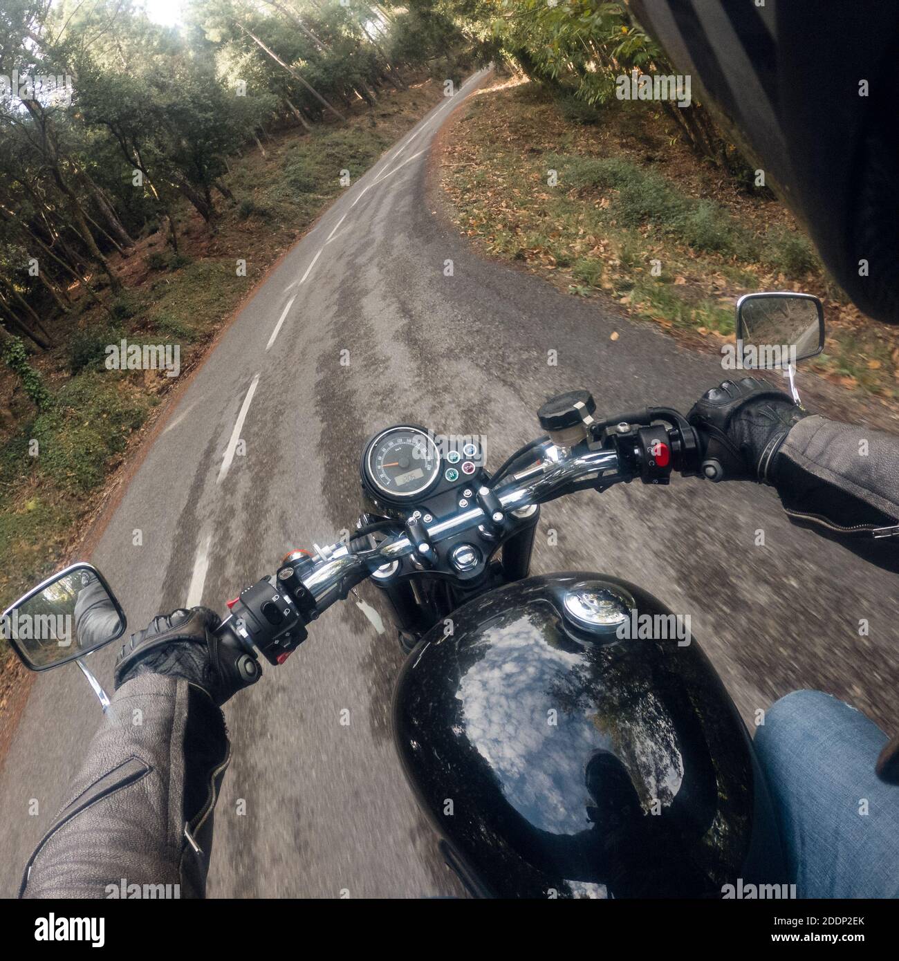 Guida di un vecchio retro nero motociclista punto di vista su una strada tortuosa Foto Stock