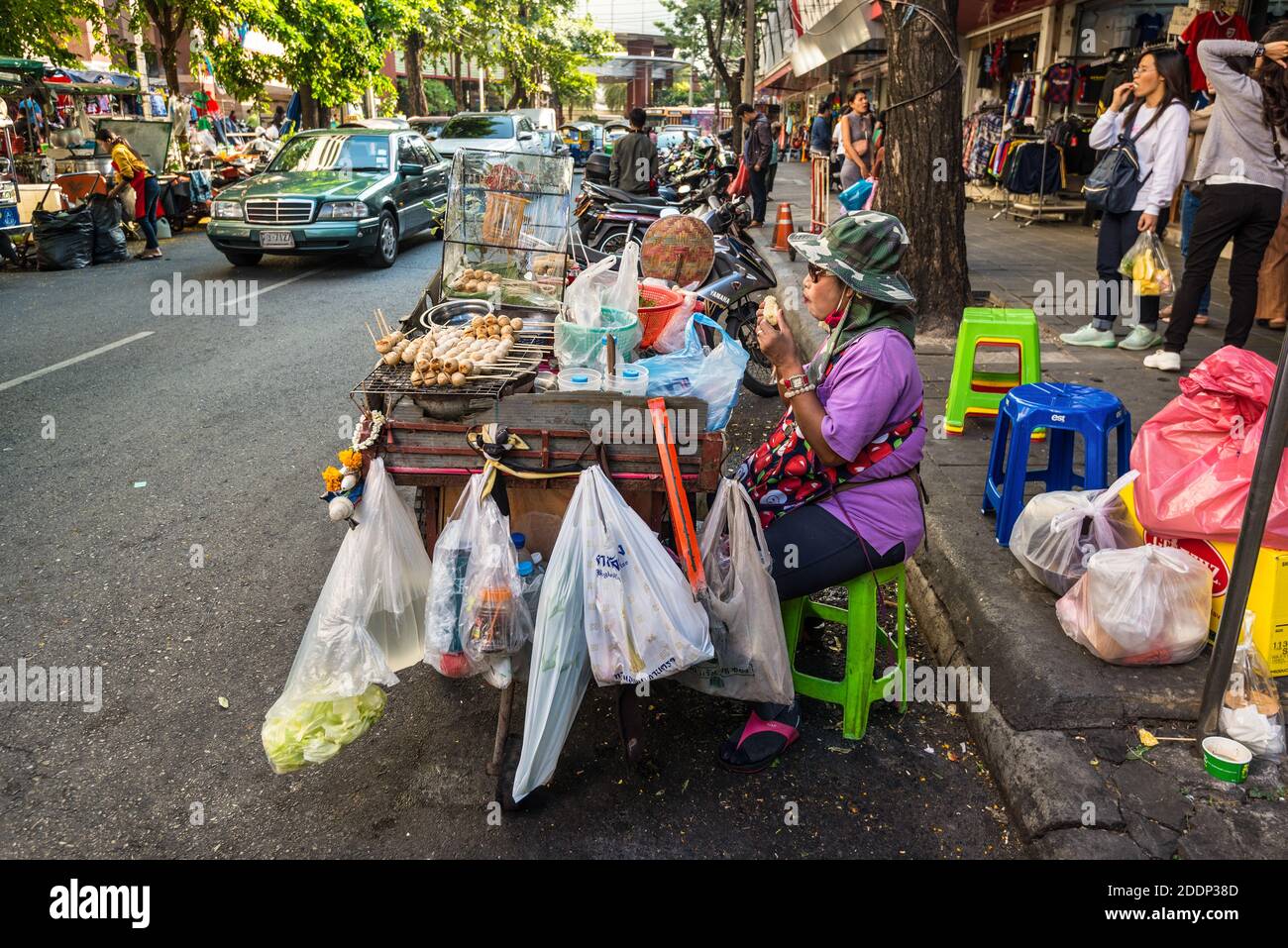 Bangkok, Thailandia - 7 dicembre 2019: Donna locale con il suo carrello che vende cibo caldo per le strade di Bangkok, Thailandia. Foto Stock
