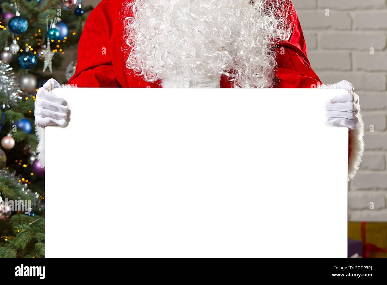 Babbo Natale con lavagna bianca e spazio per la copia. Babbo Natale sta appoggiando su una lavagna bianca con spazio per le offerte di Natale. Foto Stock