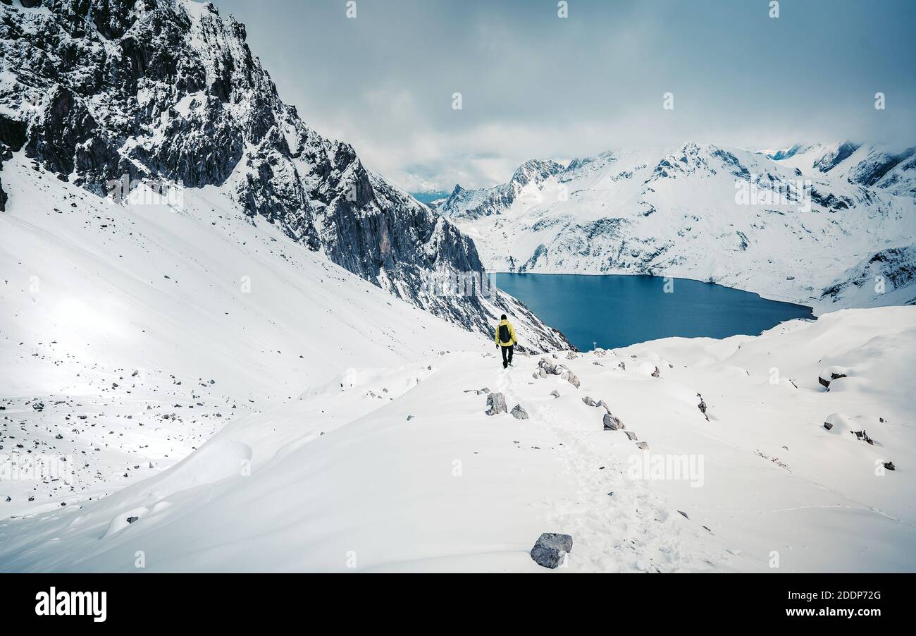 Arrampicarsi con uno zaino in cima in una giornata di sole, un uomo salì sulla montagna, persone che viaggiavano attraverso la bellissima natura selvaggia. Foto Stock