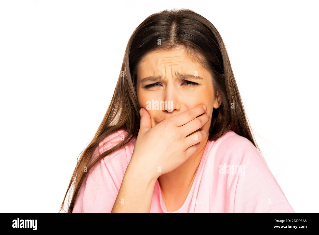 Giovane donna con forte mal di denti su sfondo bianco Foto Stock