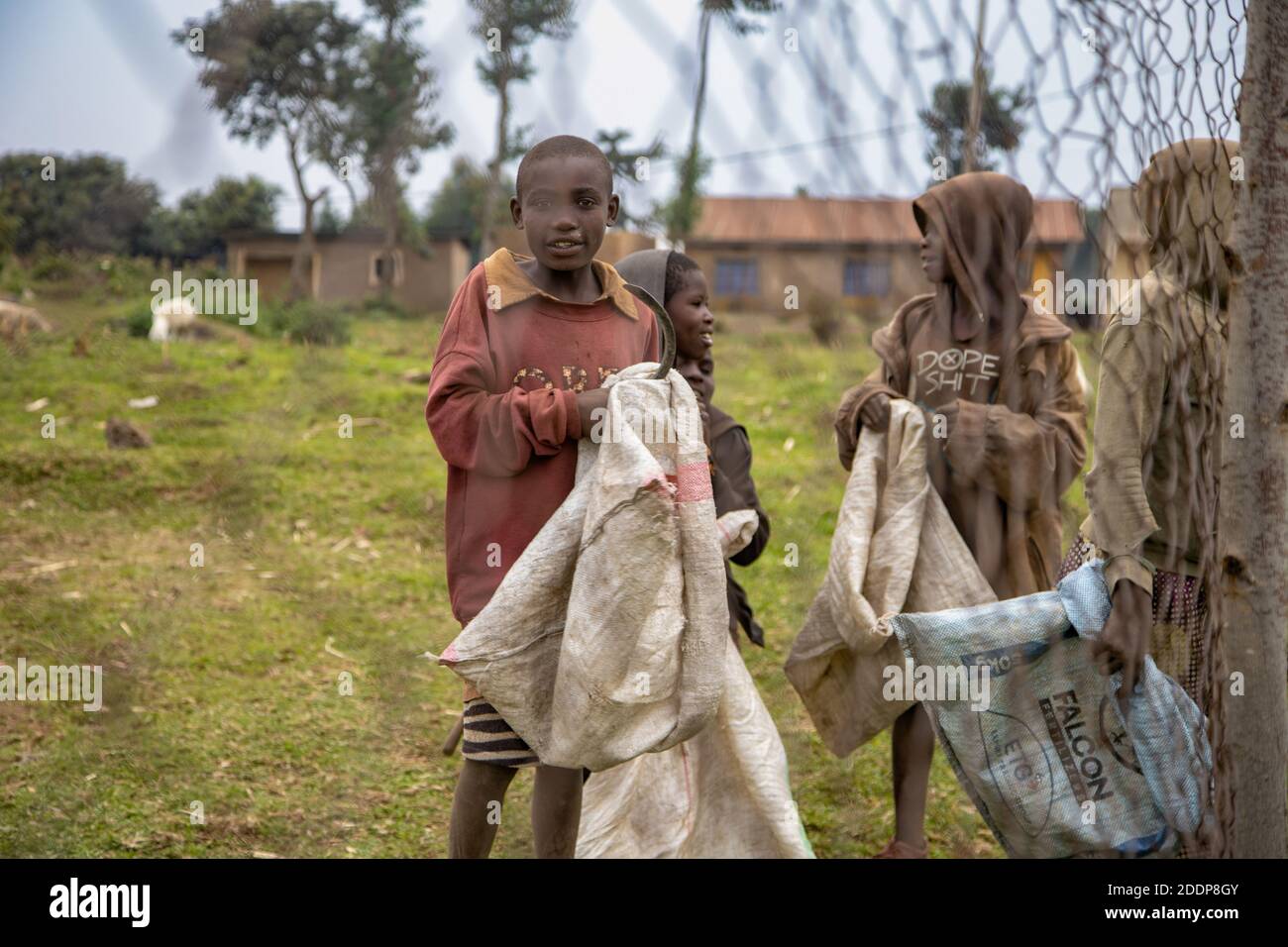 Ragazzi con i loro sacchi per portare le patate. Mudende, Provincia occidentale di Rubavu, Ruanda Foto Stock