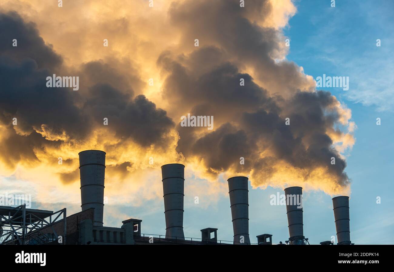 Camini industriali che emettano fumo e fuliggine nel cielo blu