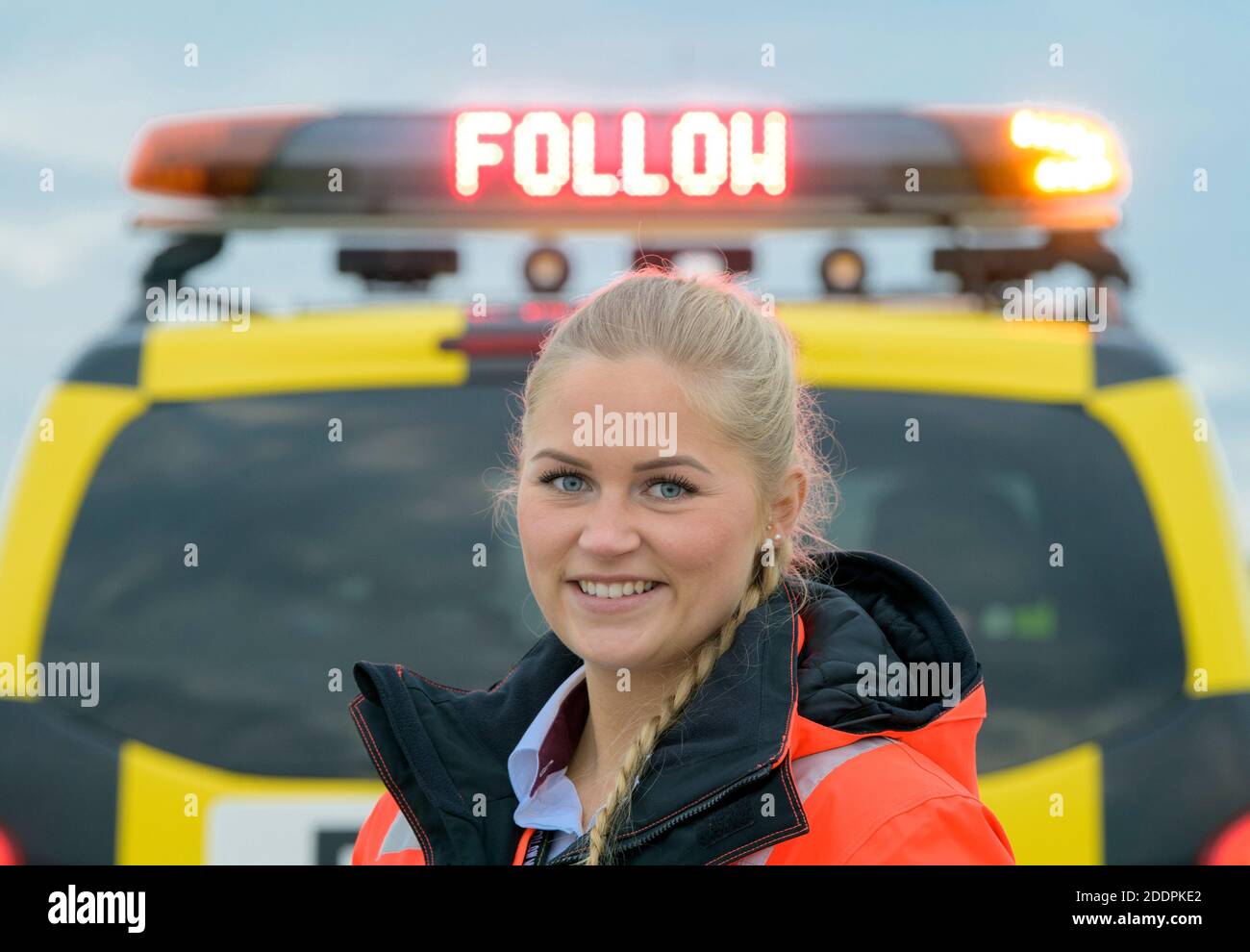 03 novembre 2020, Brandeburgo, Schönefeld: Julia Schulze, dipendente del servizio di grembiule dell'aeroporto di Berlino-Brandeburgo (BER), si trova accanto alla sua follow-me-Car sulla pista meridionale. Julia Schulze guidò l'aereo di Lufthansa al cancello durante la cerimonia di apertura dell'aeroporto della capitale. Durante una prova di due settimane con prove di vestiari, la coreografia è stata praticata con velivoli trainati per garantire che tutto andava bene. Foto: Soeren Stache/dpa-Zentralbild/ZB Foto Stock