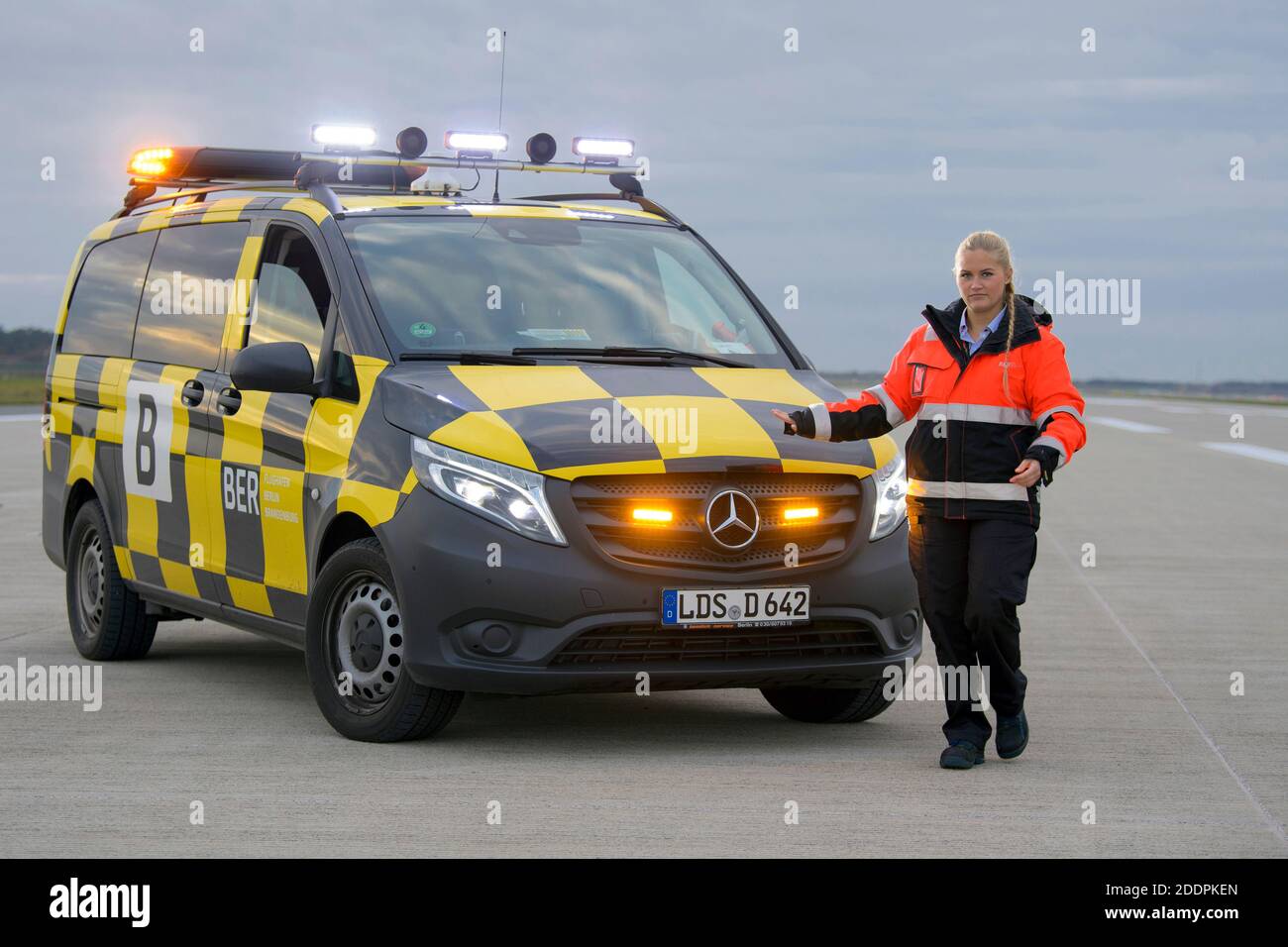 03 novembre 2020, Brandeburgo, Schönefeld: Julia Schulze, dipendente del servizio di grembiule dell'aeroporto di Berlino-Brandeburgo (BER), si trova accanto alla sua follow-me-Car sulla pista meridionale. Julia Schulze guidò l'aereo di Lufthansa al cancello durante la cerimonia di apertura dell'aeroporto della capitale. Durante una prova di due settimane con prove di vestiari, la coreografia è stata praticata con velivoli trainati per garantire che tutto andava bene. Foto: Soeren Stache/dpa-Zentralbild/ZB Foto Stock