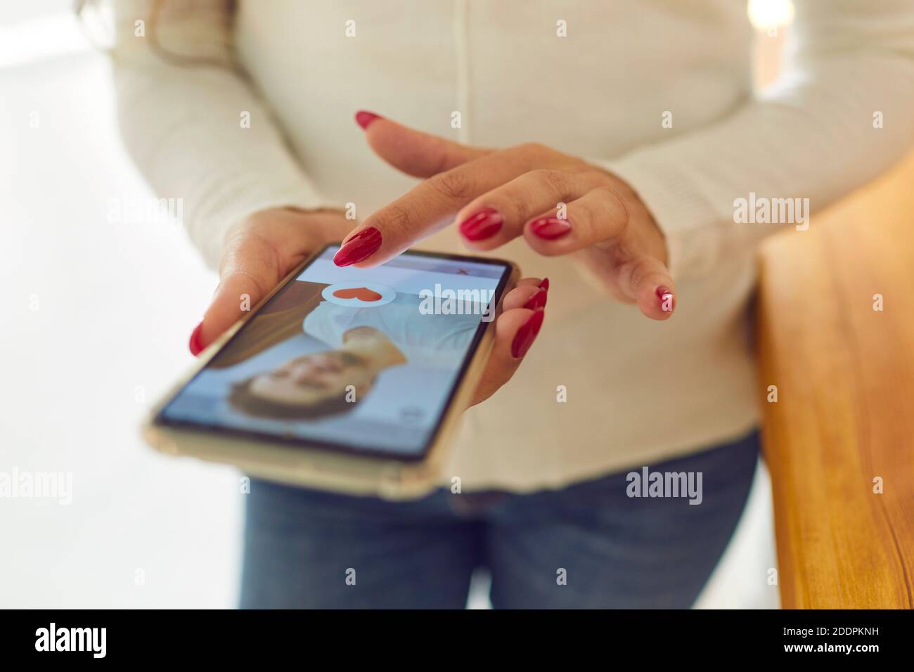 Le mani di Womans scelgono il profilo maschio nell'applicazione di datazione in linea sullo smartphone Foto Stock