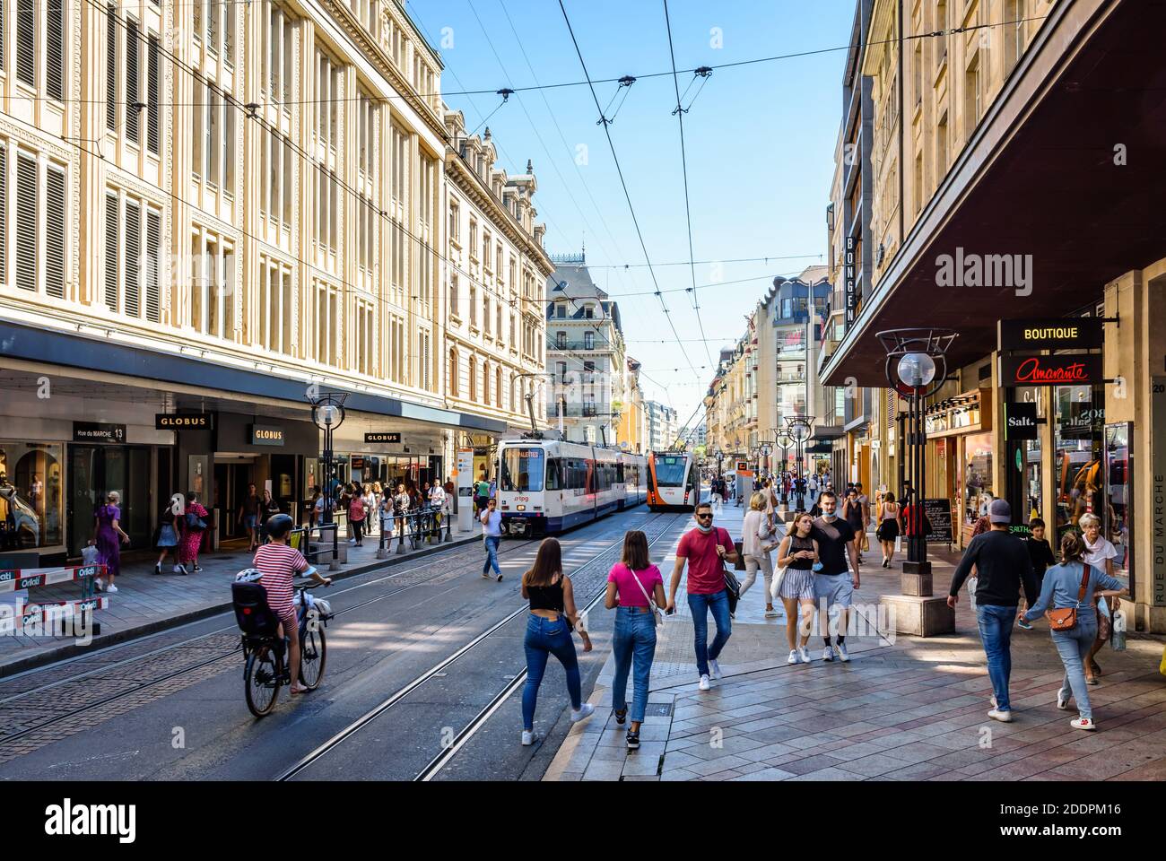 Coppie, famiglie e amici passeggiano nella principale via dello shopping di Ginevra, servita da tram e filobus, in una soleggiata giornata estiva. Foto Stock