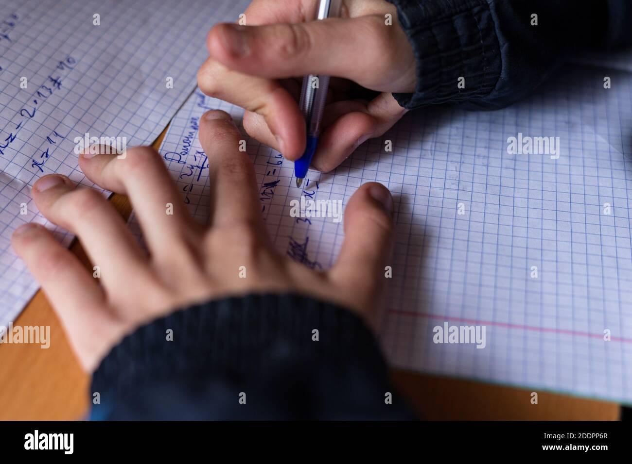 Il ragazzo scrive in un taccuino. Il bambino sta facendo i compiti. Penna e notebook. Foto Stock