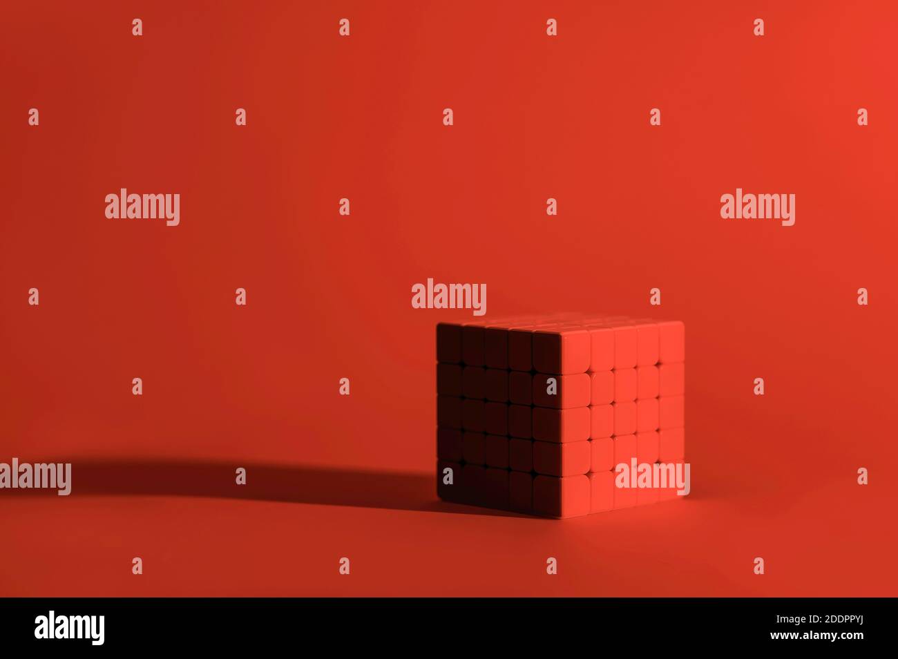 Monocromatico, rosso, cubo di Rubik 5x5 su sfondo rosso, cubo magico, cubo puzzle Foto Stock
