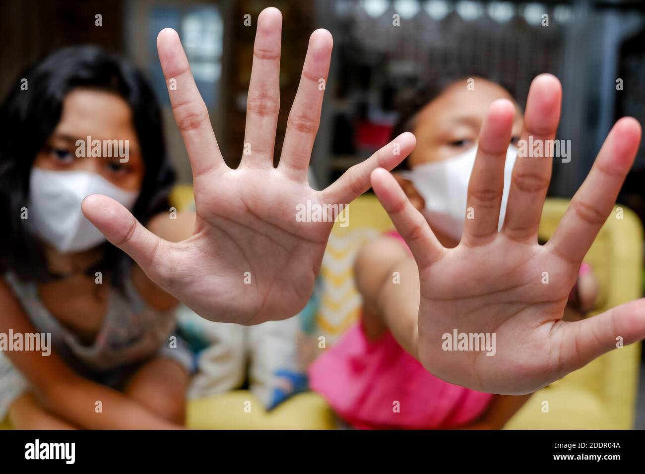 Sudest Asiatico Teenage Girls indossare maschera medica faccia fare arresto Segni gesti con le mani Foto Stock