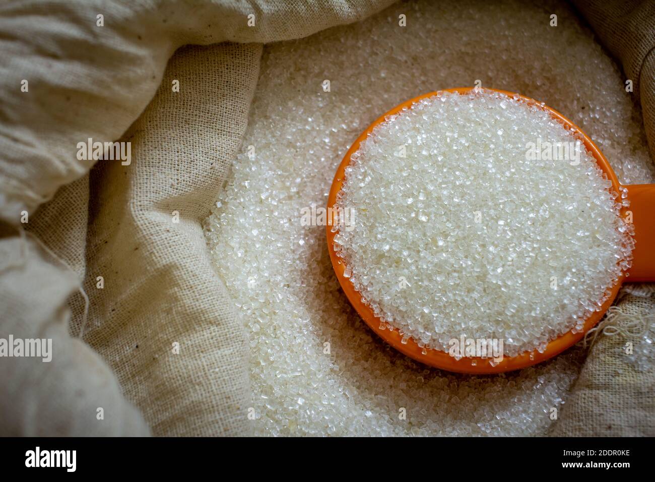 Zucchero di canna bianco granulato in un sacco con una paletta. Foto Stock