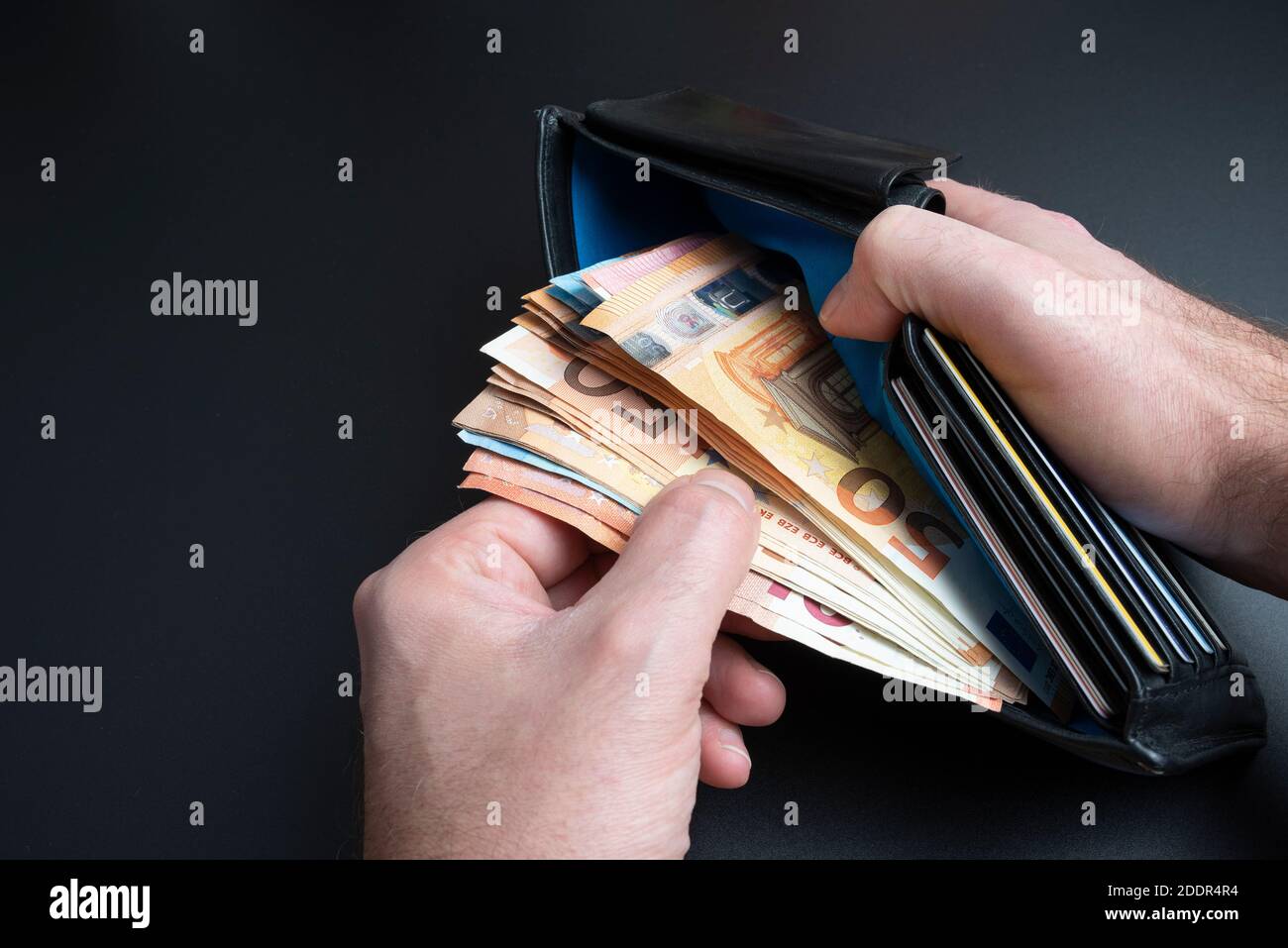 primo piano, alto angolo di visione delle mani di una persona che prende denaro da borsetta o portafoglio Foto Stock