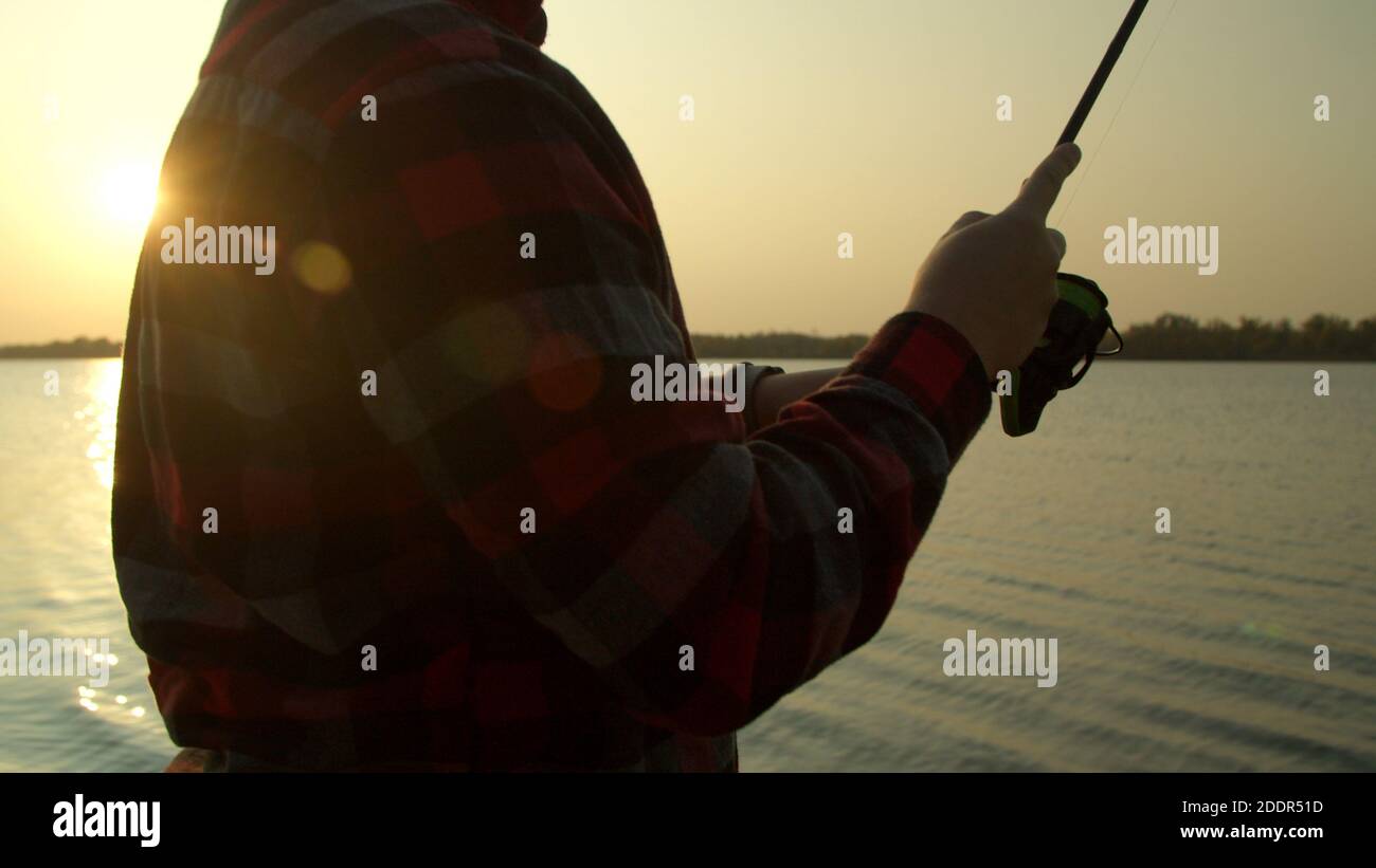 Pescatore maschio che prende selfie con pesci vicino all'acqua Foto Stock