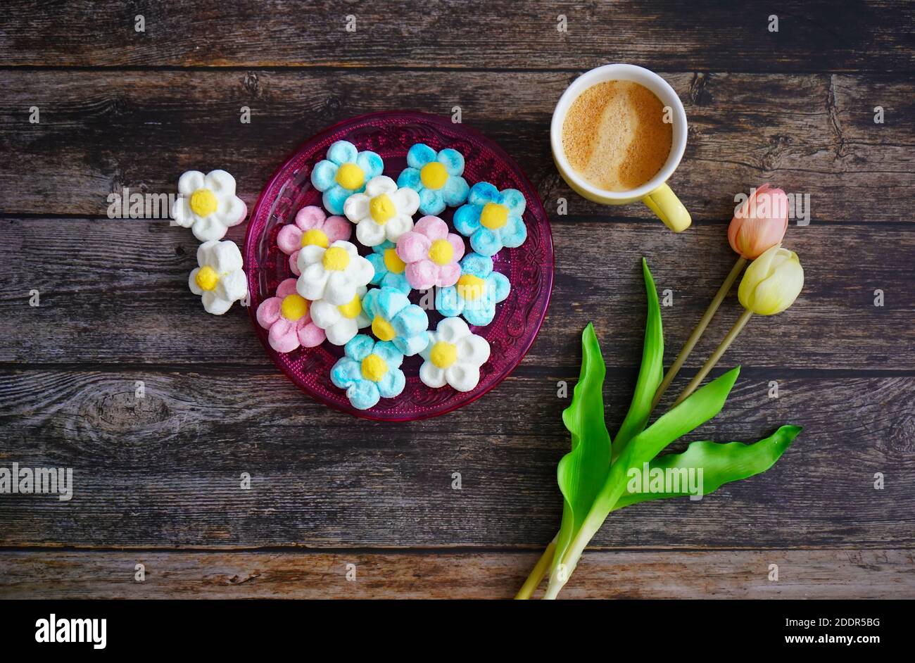 Tavolino da caffè tedesco con dolci alla schiuma, caffè e tulipani per la decorazione. Foto Stock