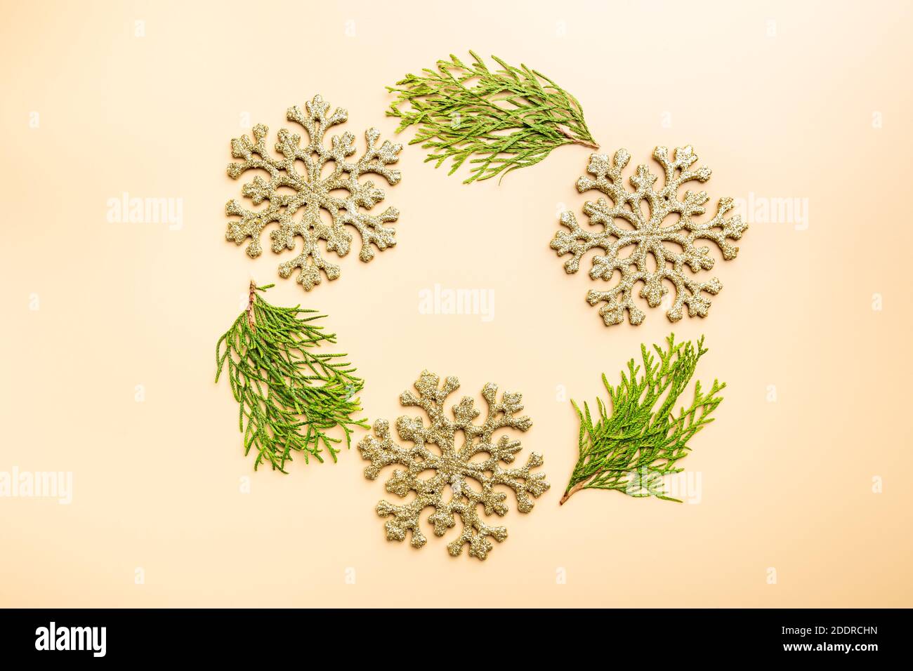 Decorazioni in oro natalizio con rami thuja su sfondo Set Sail Champagne, vista dall'alto. Inverno decorazione sfondo Foto Stock