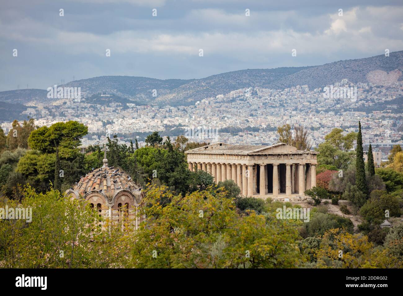 Antico tempio di Hefaestus e cupola della chiesa greco-ortodossa, il paesaggio urbano di Atene e lo sfondo del cielo nuvoloso. Grecia Foto Stock