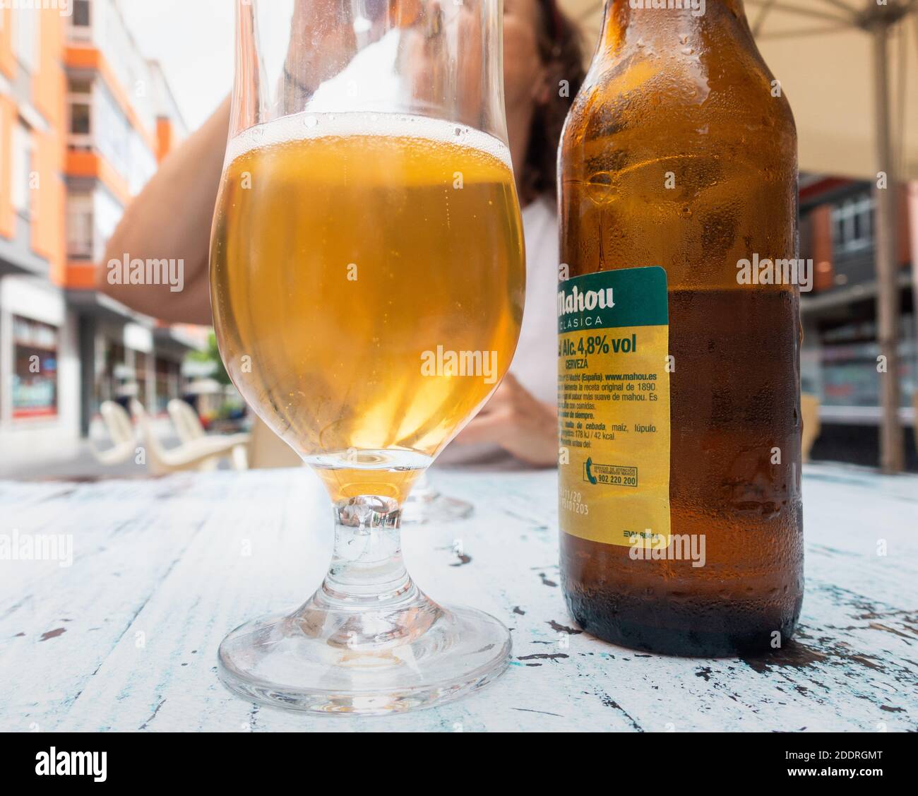 Donna matura che beve birra spagnola Mahou al bar/caffetteria all'aperto Spagna Foto Stock