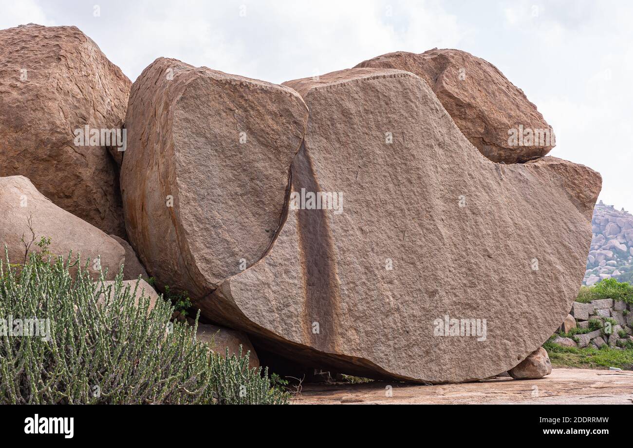 Hampi, Karnataka, India - 4 novembre 2013: Complesso del Tempio di Virupaksha. Closeup di enorme masso marrone tagliato ordinatamente a metà ad un lato piatto liscio, riposa un Foto Stock