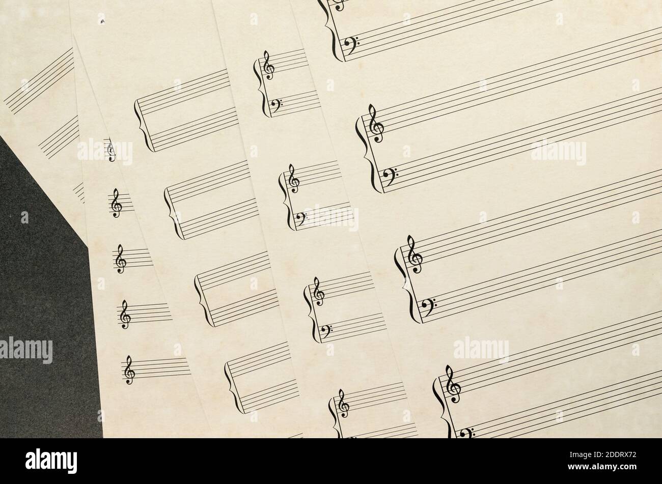 Una panoramica dall'alto della carta musicale vuota obsoleto con personale e scogli su una superficie grigia Foto Stock