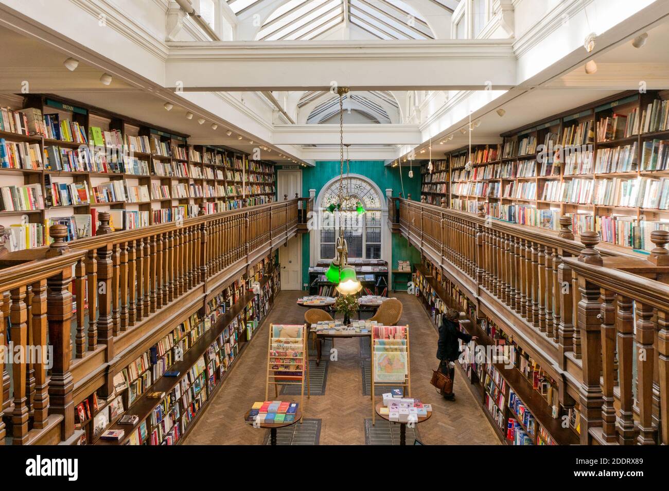 Interni di Daunt Books, Marylebone, Londra, UK; woman browsing books. Foto Stock