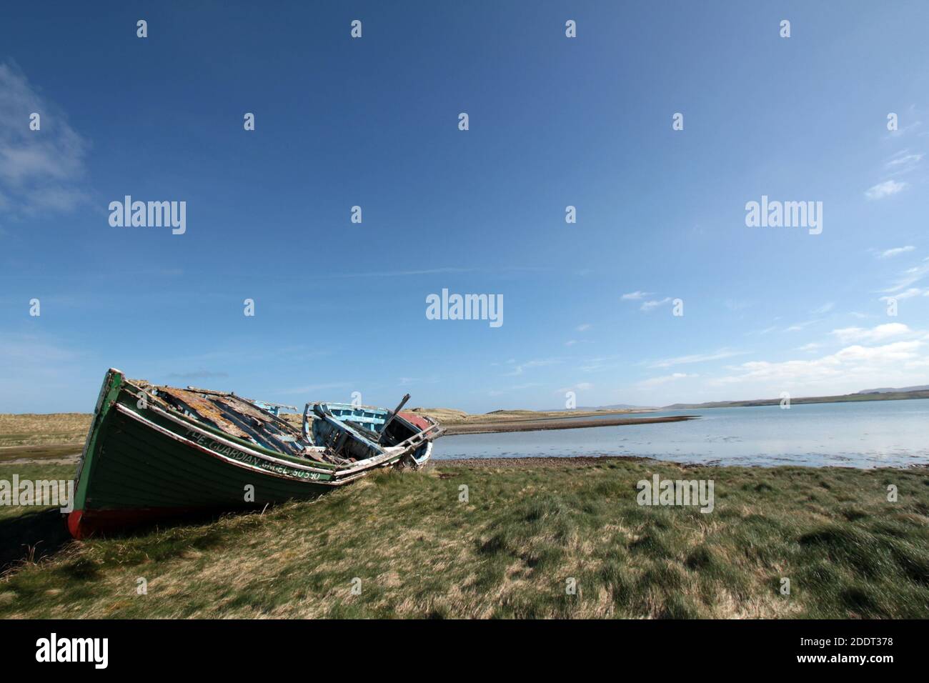 Il relitto decadente di una vecchia barca da pesca si trova sopra l'erba vicino al litorale Foto Stock