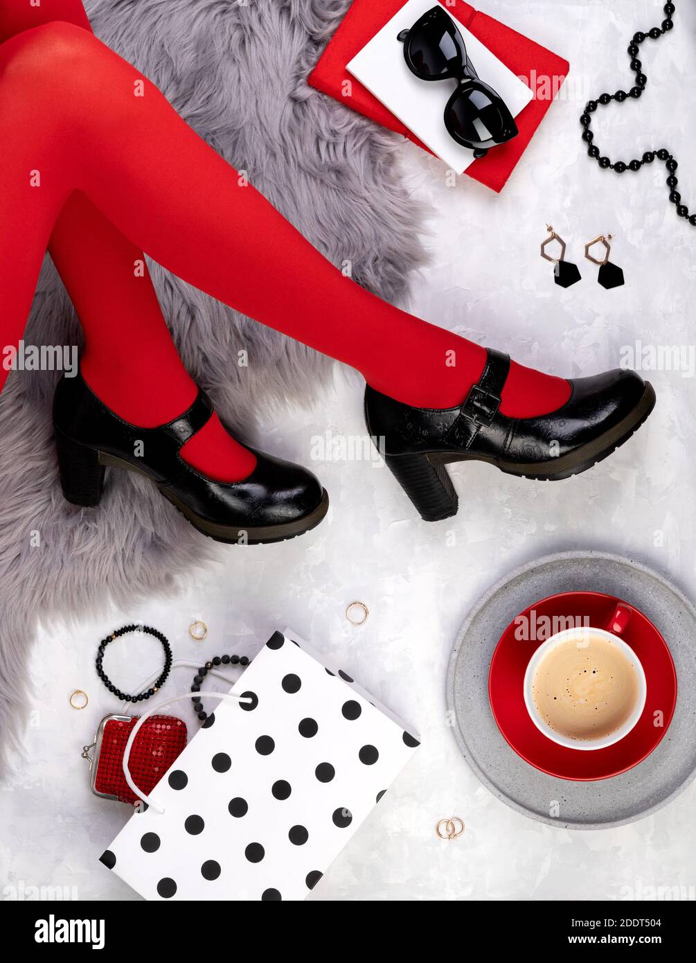 Gambe donne in scarpe alla moda su fondo grigio furry Foto Stock