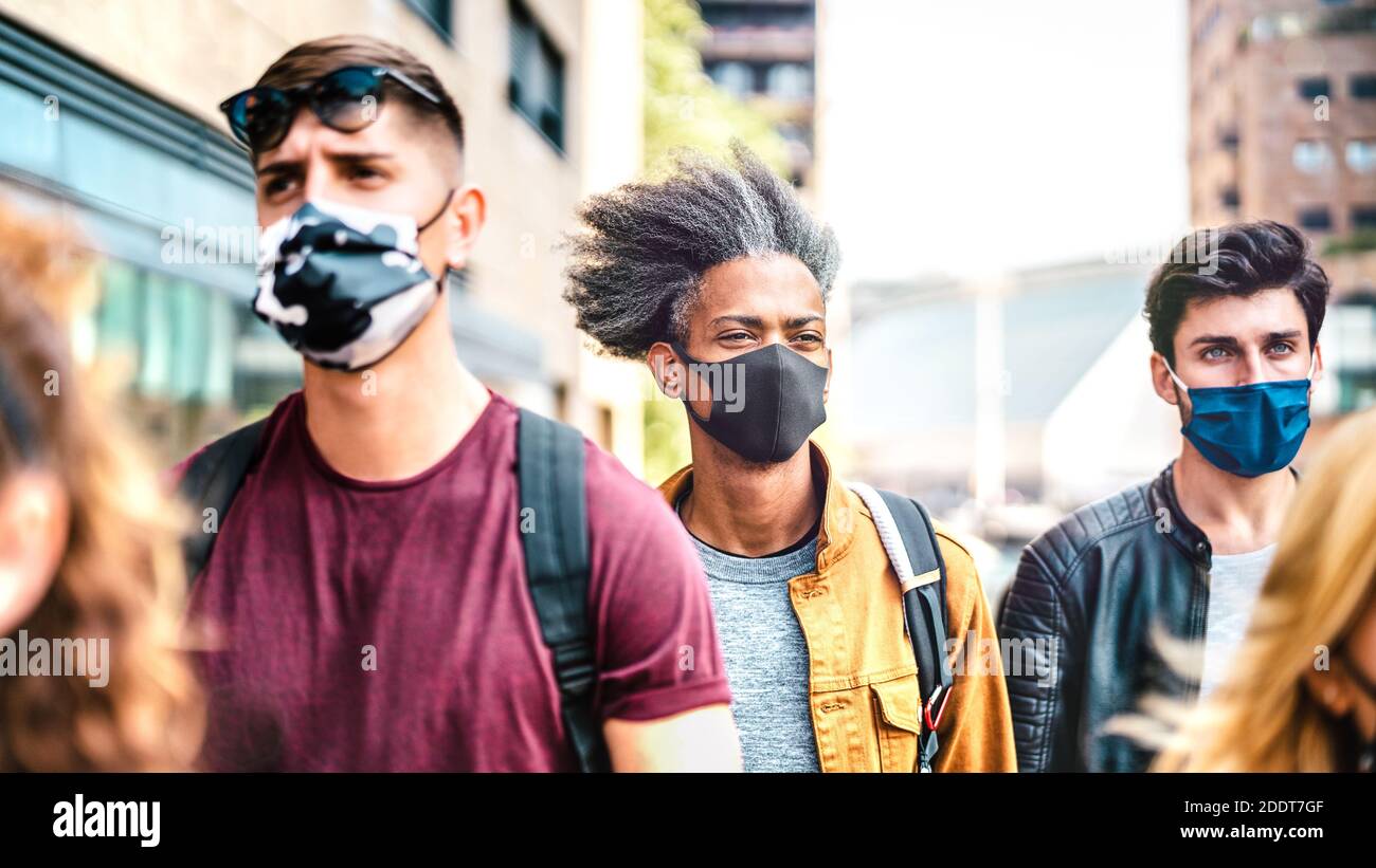 Folla multirazziale che cammina sulla strada della città - nuovo stile di vita normale concetto con il viso dei giovani coperto da maschera protettiva Foto Stock