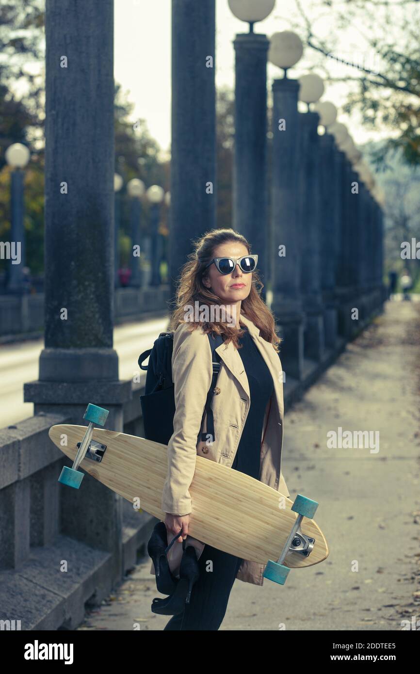 Donna attiva con longboard. Concetto di stile di vita urbano. Foto Stock