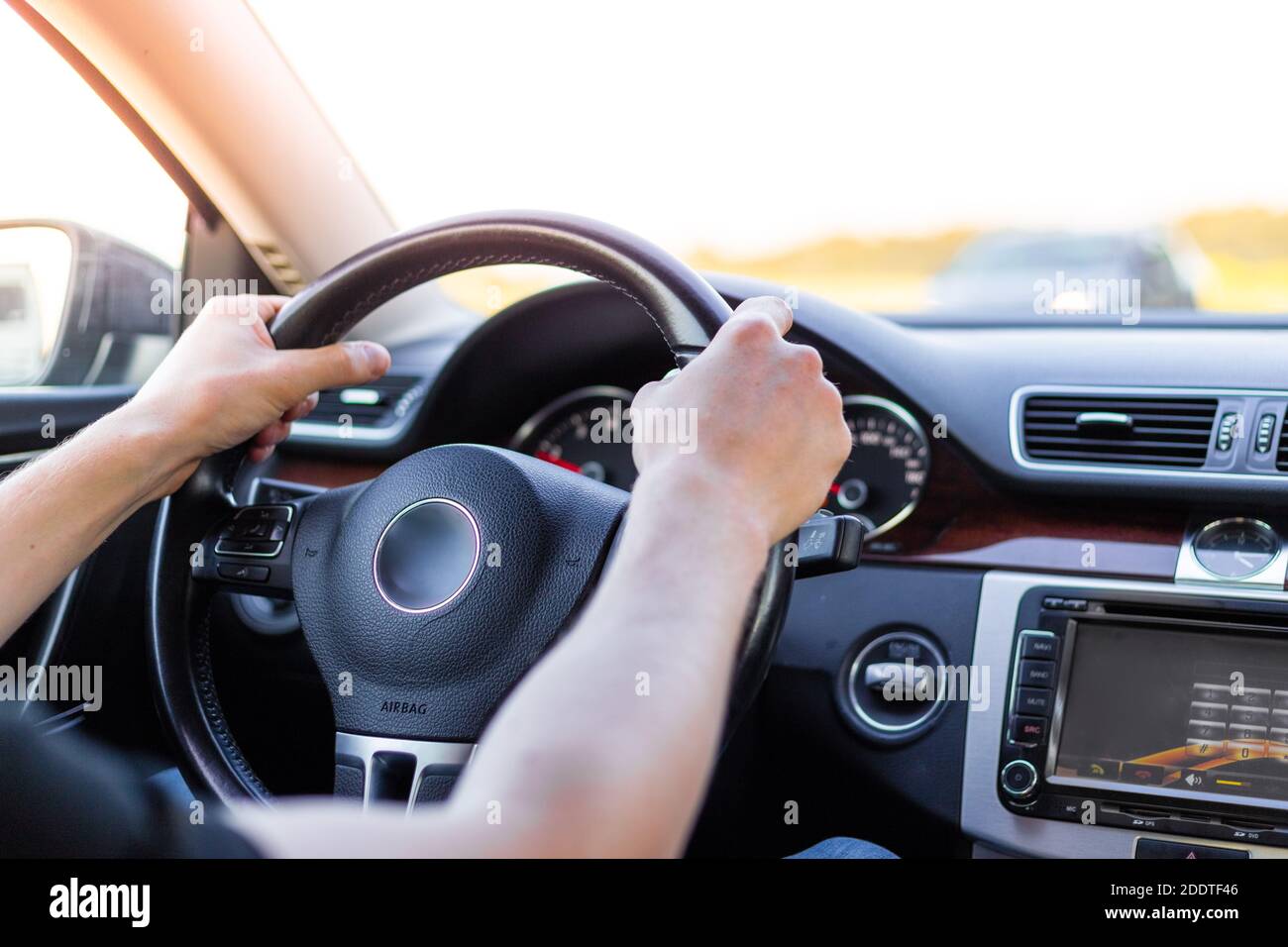 Un uomo tiene il volante di una macchina con due mani, una vista dal  salone. Guida in auto Foto stock - Alamy
