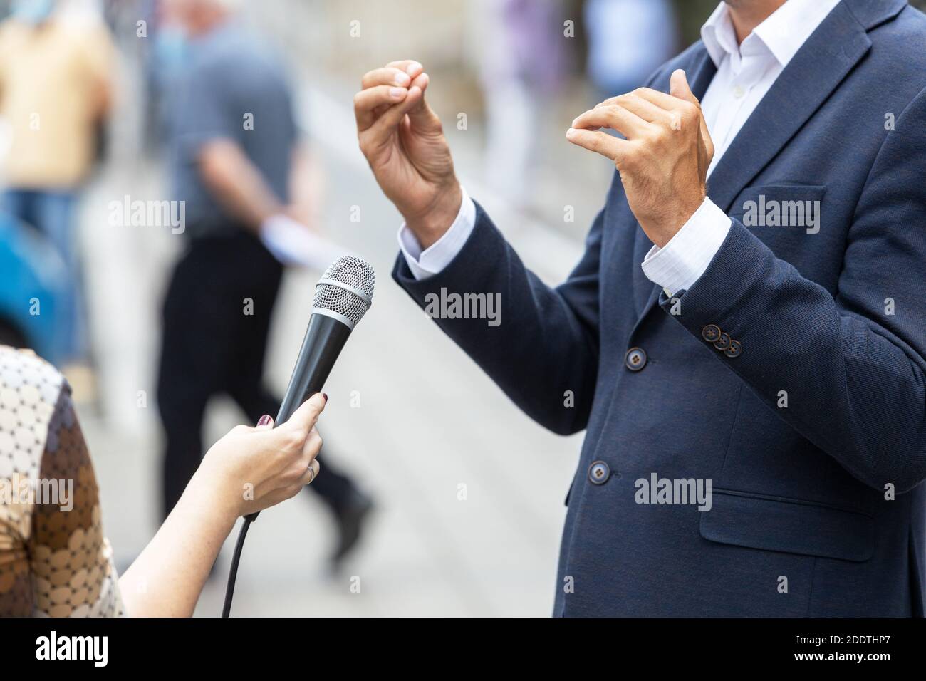 Reporter che fa l'intervista di stampa con la persona irriconoscibile. Concetto VOX populi. Foto Stock