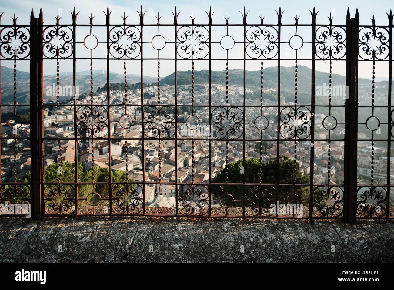 Oltre una ringhiera in ferro battuto che sfocia nel paesaggio urbano sulla montagna di Mistretta Città di Sicilia arte e cultura testimonianza Foto Stock