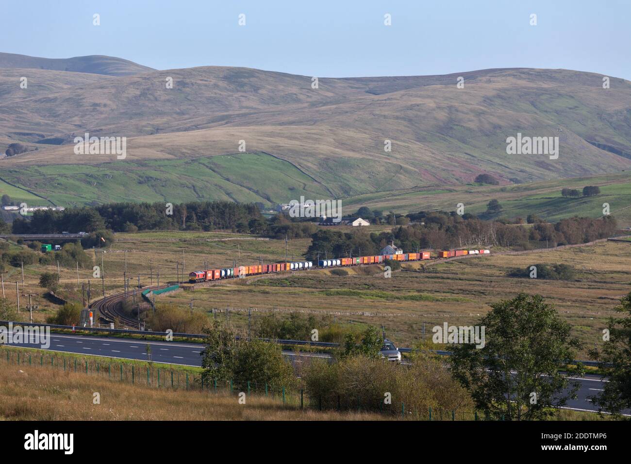 DB Cargo rail UK classe 66 locomotiva diesel arrampicata Shap banca a Scout Green con un Liverpool Seaforth a Mossend treno merci container Foto Stock