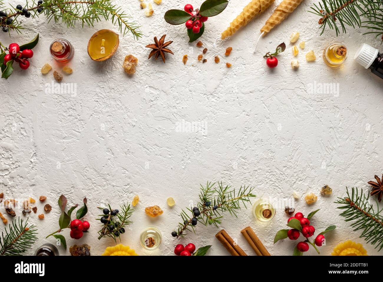 Selezione di olii essenziali natalizi con verdino, ginepro, incenso e altre erbe, con spazio di copia al centro Foto Stock