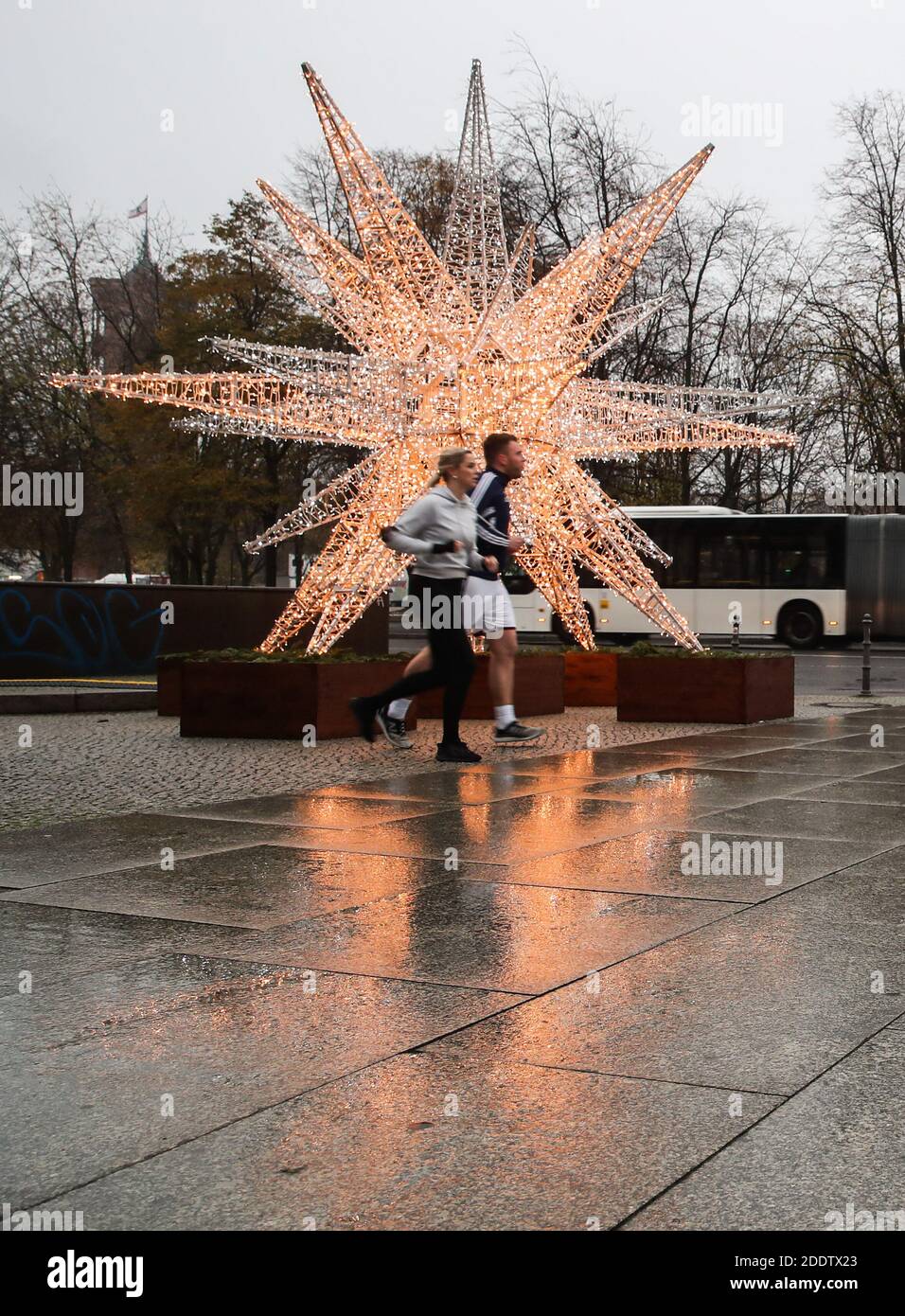 Berlino, Germania. 26 Nov 2020. I runner si sono passati a una decorazione di luci natalizie a Berlino, capitale della Germania, 26 novembre 2020. A seguito dell'aumento dei tassi di infezione da COVID-19 in Germania, il 25 novembre i governi federali e statali hanno deciso che il blocco parziale, compresa la chiusura di ristoranti, bar, teatri e strutture ricreative, sarebbe stato prorogato fino al 20 dicembre. Credit: Shan Yuqi/Xinhua/Alamy Live News Foto Stock