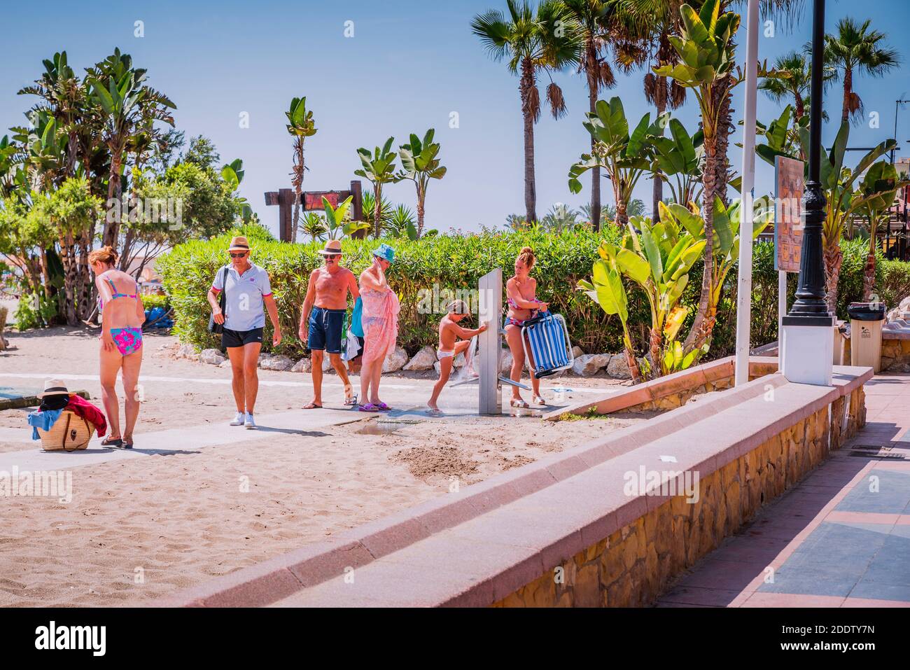 I turisti si staccano dalla sabbia quando lasciano la spiaggia. Spiaggia la Carihuela. Torremolinos, Málaga, Costa de Sol, Andalusia, Spagna, Europa Foto Stock