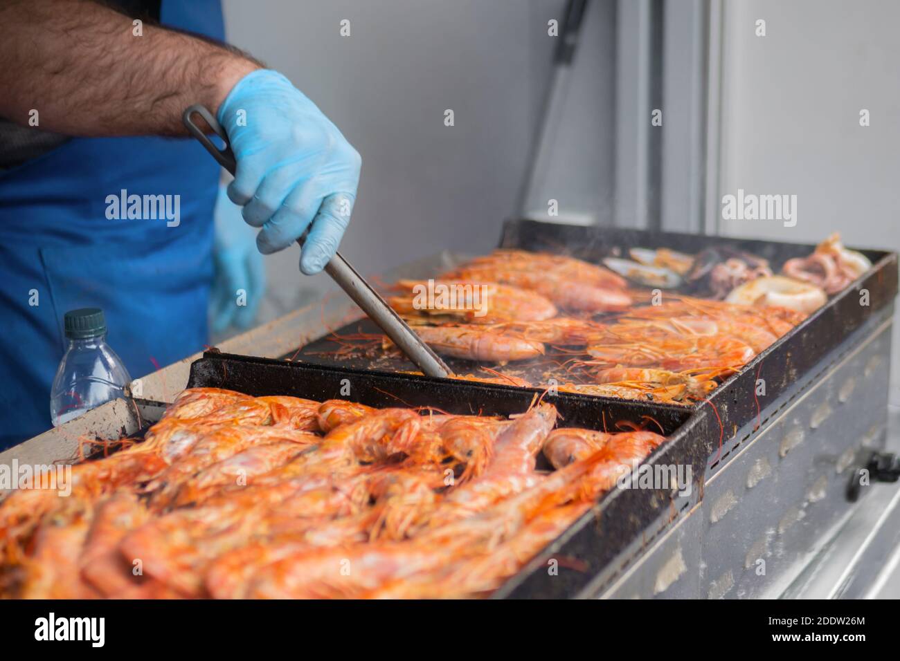 Chef che cucinano gamberi rossi di langoutine freschi, gamberi alla griglia a cibo locale estivo Foto Stock