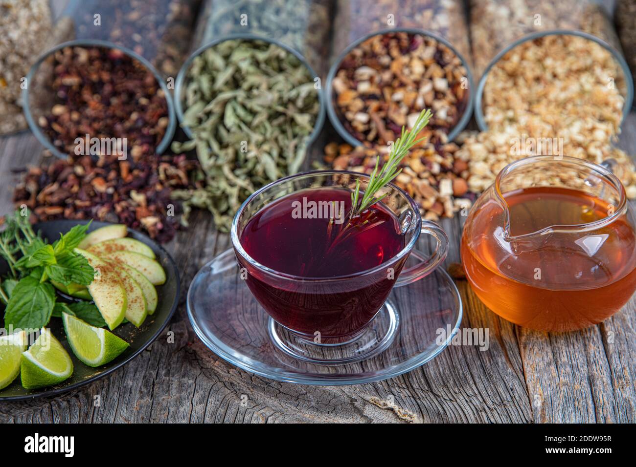 Tè misto alle erbe, tè invernale. Per malattia e lotta contro l'influenza. Foglie di menta, miele con cucchiaio e tazza di tè caldo. Concetto di erborismo e apo moderno Foto Stock