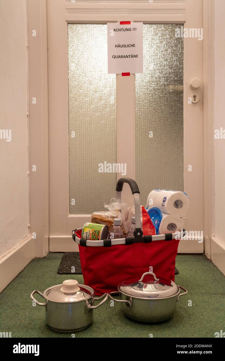 Immagine simbolica quarantena domestica, l'uomo è sospettato di infezione corona, a casa in isolamento, segnale di avvertimento per i visitatori alla porta piatta, comunicat Foto Stock