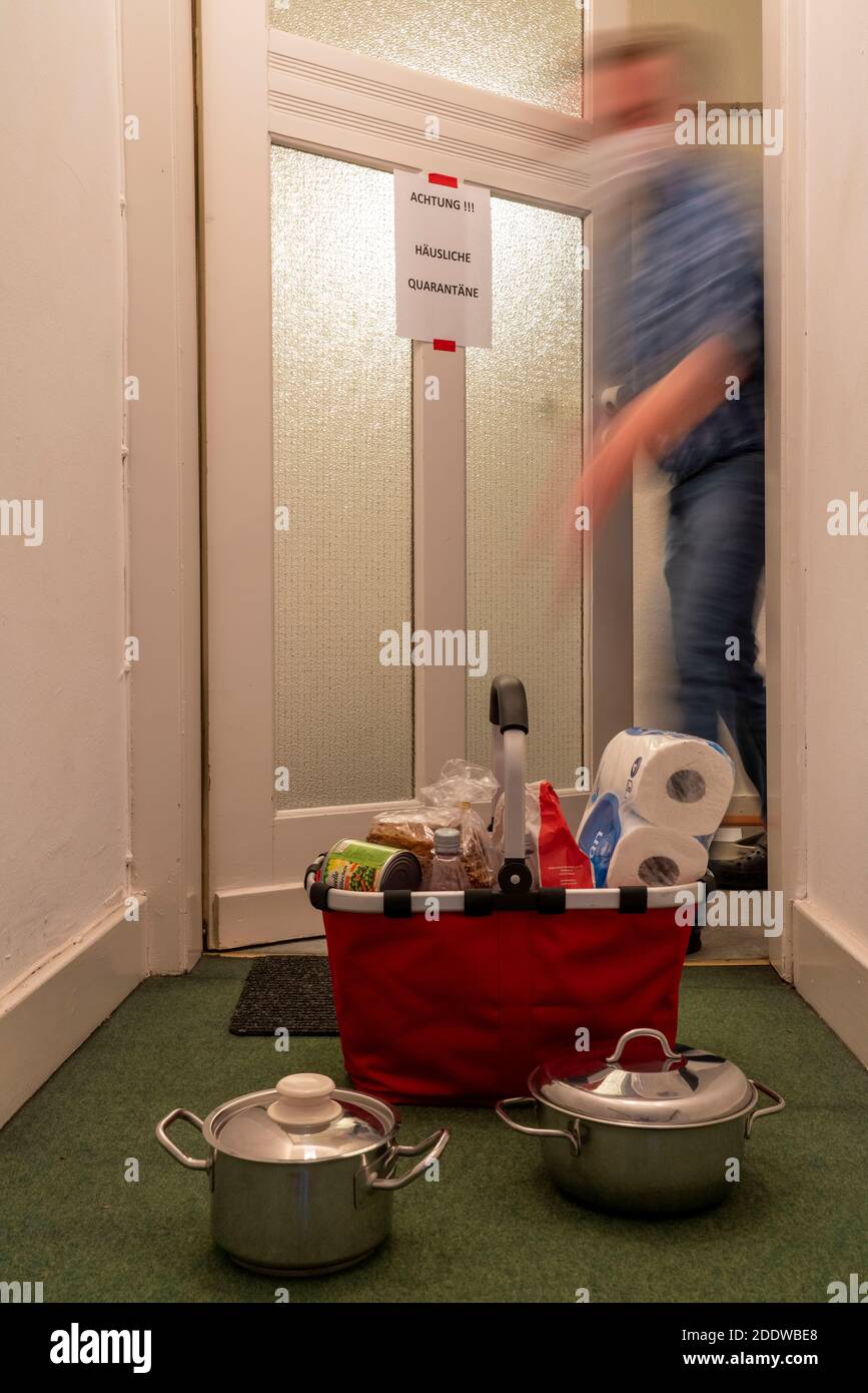 Immagine simbolica quarantena domestica, l'uomo è sospettato di infezione corona, a casa in isolamento, segnale di avvertimento per i visitatori alla porta piatta, comunicat Foto Stock